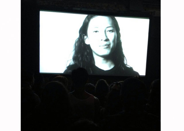 Alexander Wnag no telão anunciado a distribuição de roupas da coleção da marca T by Alexander Wang - Foto: Reprodução