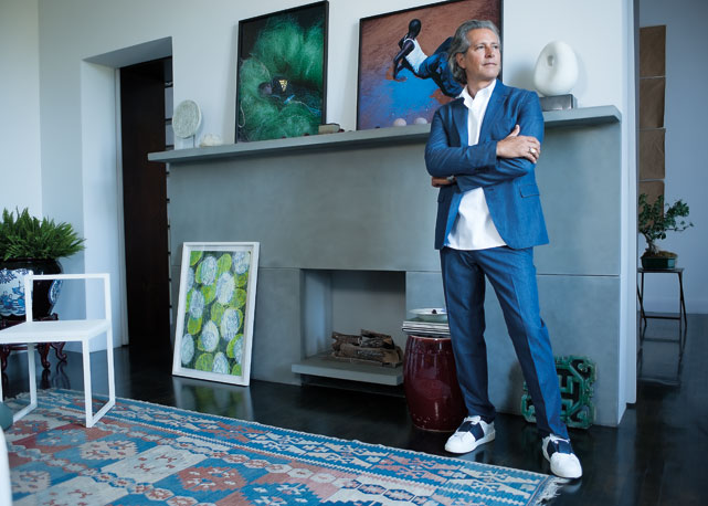Carlos usa total look Valentino. Vaso antigo bleu de chine, cadeira De Padova, tapete comprado em Istambul. Sobre a lareira, fotos de Viviane Sassen e escultura inglesa vintage - Foto: Roberta Krasnig/divulgação