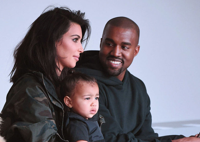 Kim Kardashian, Kanye West e North West na primeira fila do desfile - Foto: Getty Images