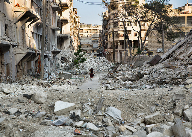 Child running through the Rubble of the city of Aleppo. Aleppo, Syria on May 9, 2014 - Foto: Gabriel Chaim
