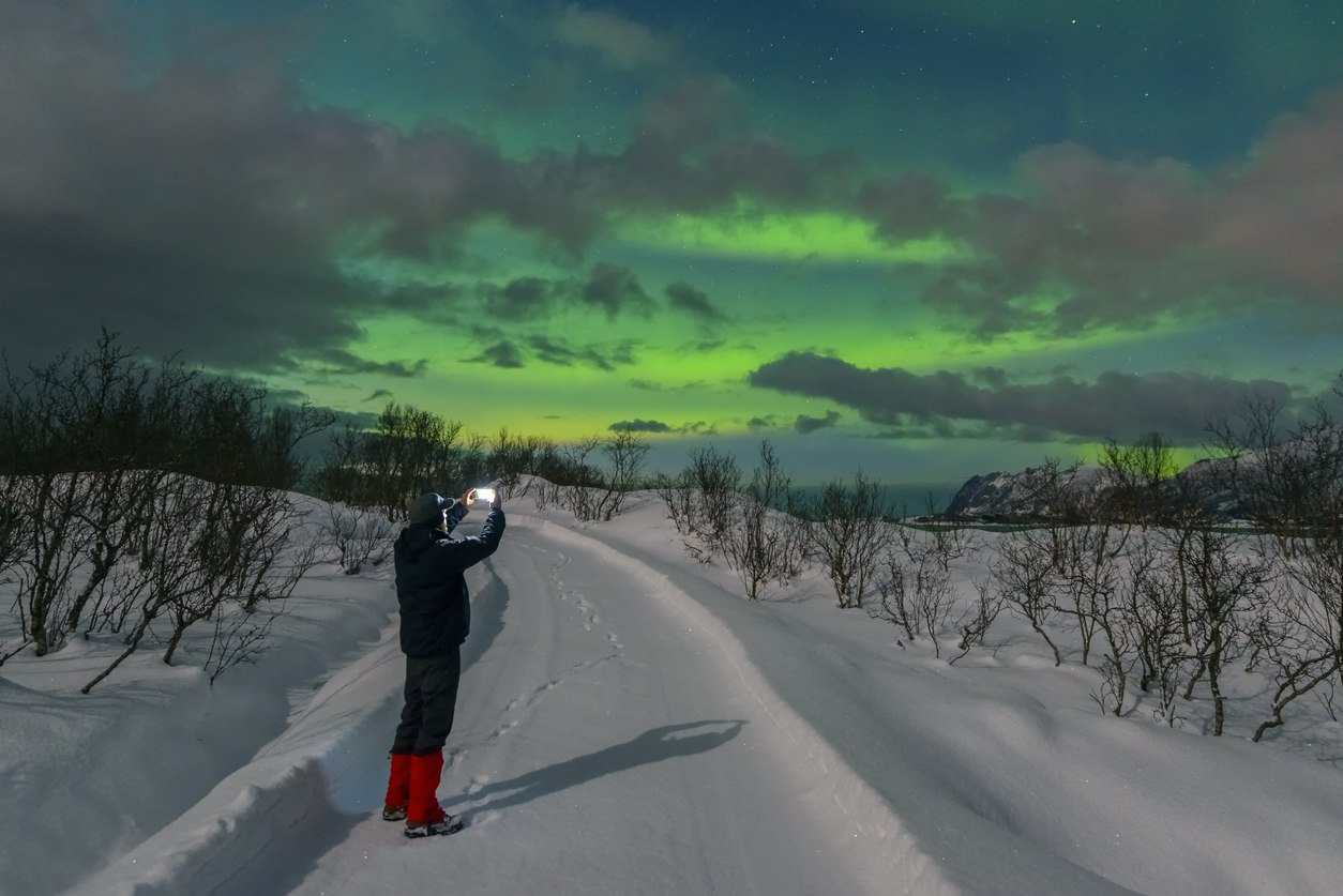 Homem fotografa a aurora boreal, em Tromso - Foto: Divulgação