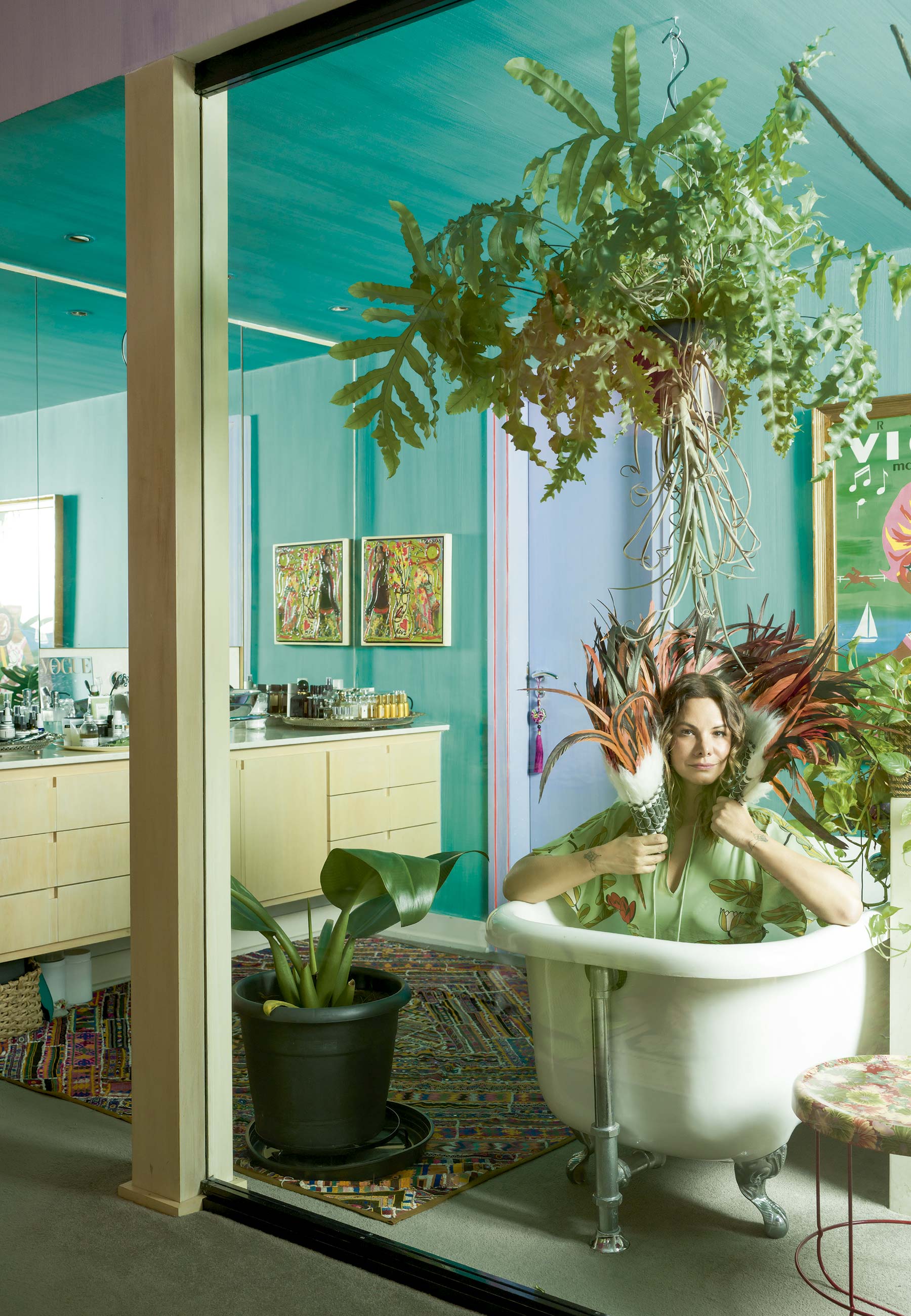 Adriana segura cocar indígena comprado em Alto Paraíso, em Goiás; tapete comprado na Índia; pintura de Isabelle Tuchband; e mesinha de Tomita Kazuhiko para Moroso - Foto: Christian Maldonado