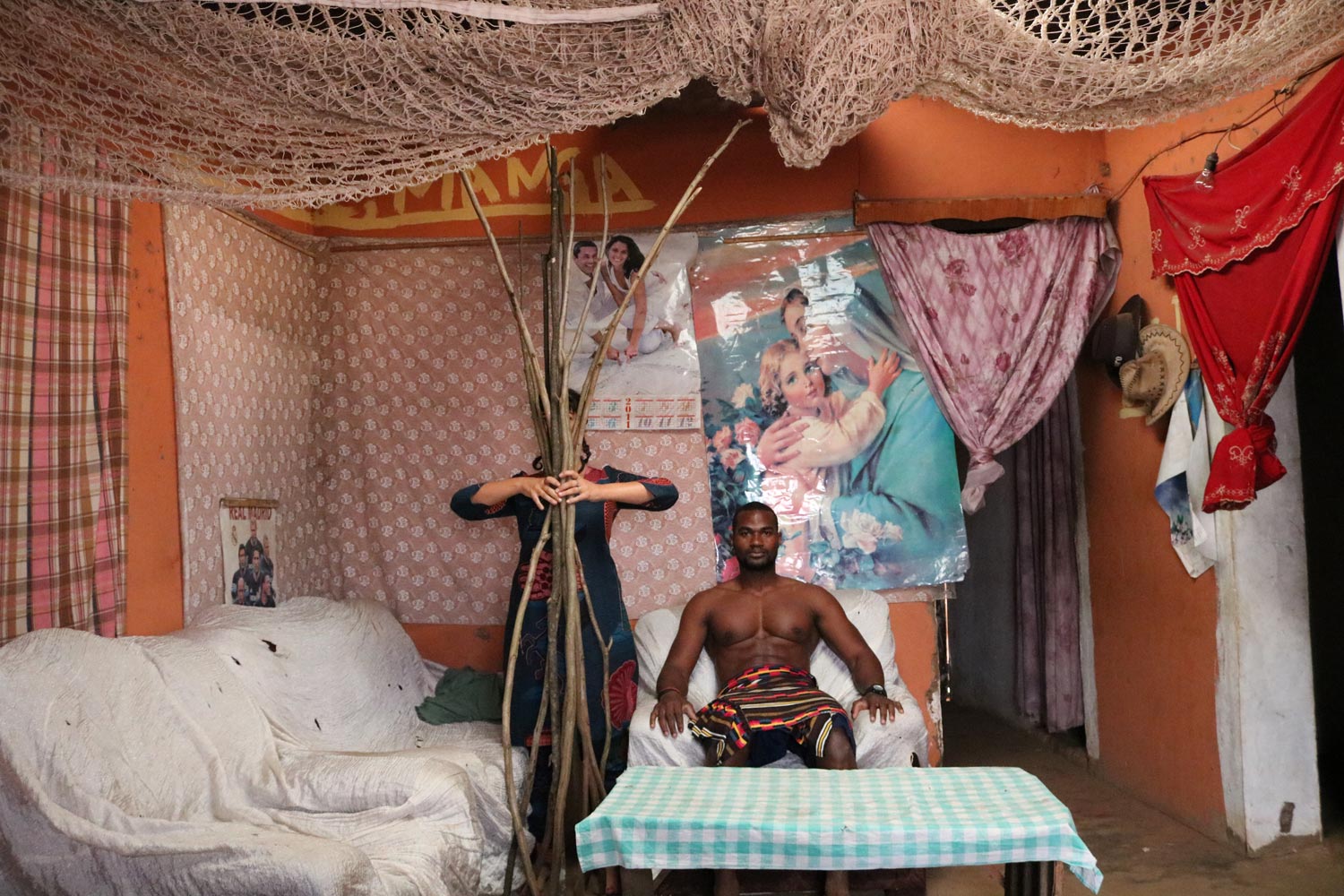 Nesta obra de Rita, o neto do rei de Uíge senta-se ao “trono” cercado por ícones da cultura pop e branca: crítica à invasão e à escravidão - Foto: Divulgação